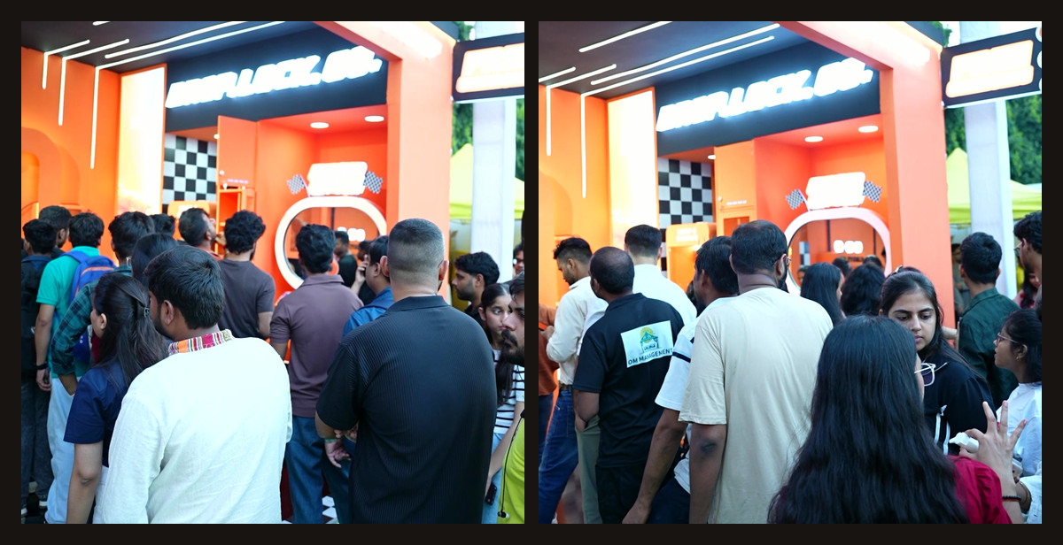 Students crowding the entrance of Ambrane's orange stall at Rendezvous 2026, IIT Delhi, with the photo booth's oval mirror visible inside