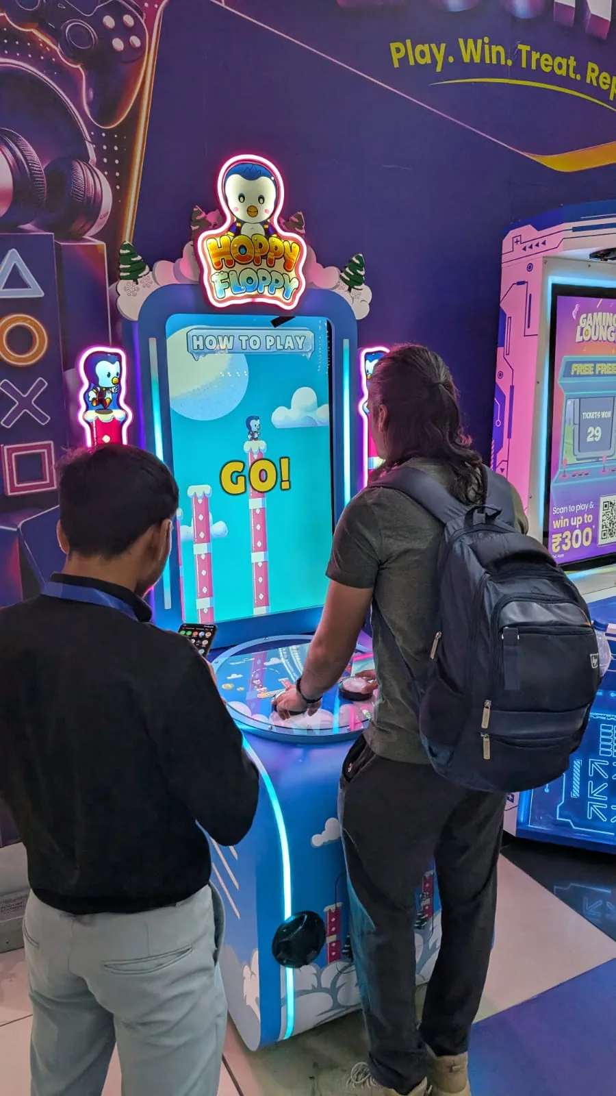 Two travellers playing Hoppy Floppy in the Adani One Gaming Lounge