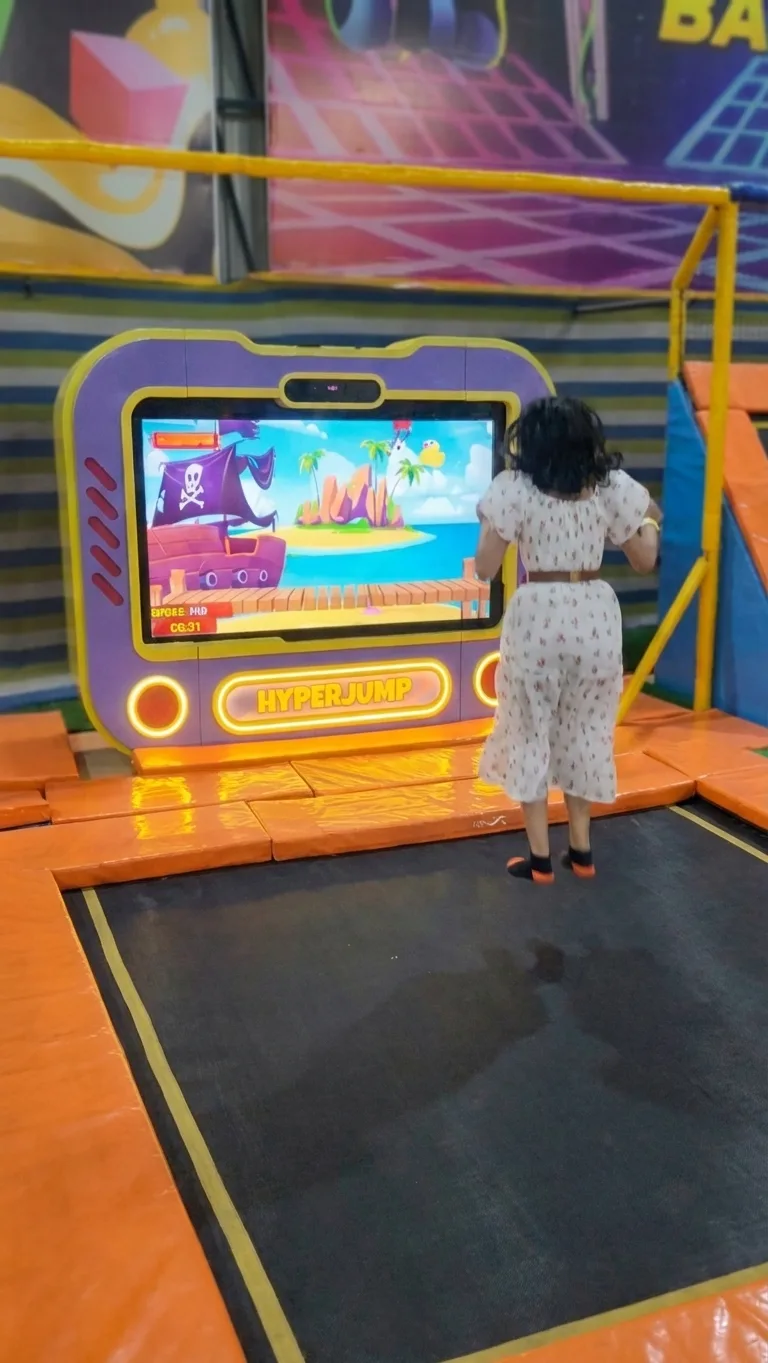 Woman standing on the trampoline in front of the Hyper Jump screen