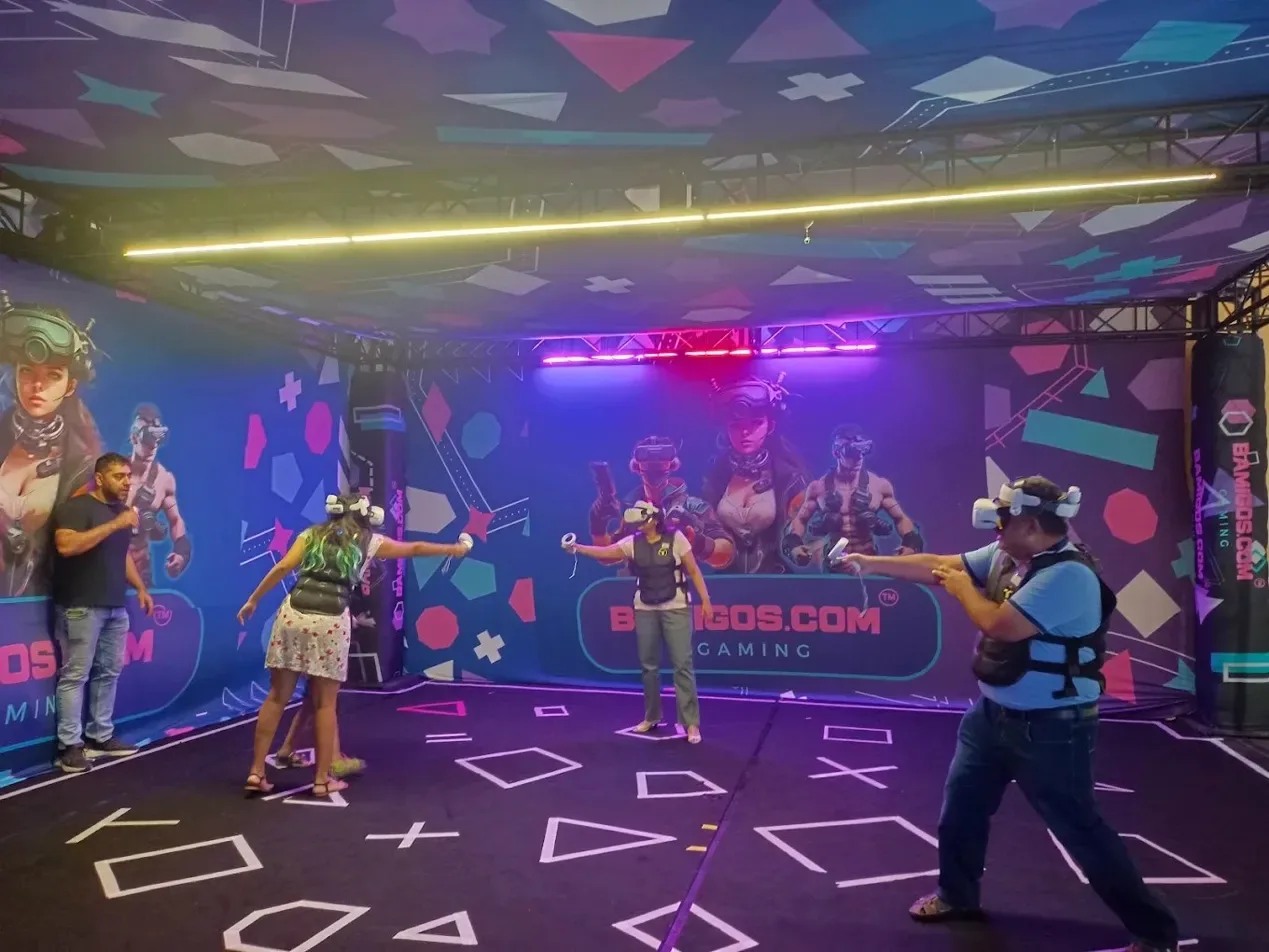 Players in VR headsets inside the neon-lit Metablaster arena