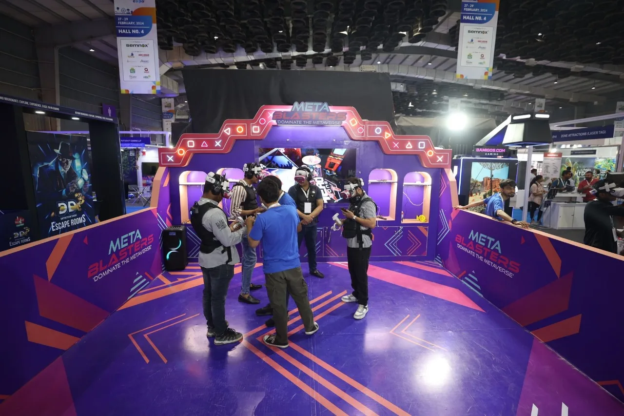Players in headsets inside purple META BLASTERS stand at expo
