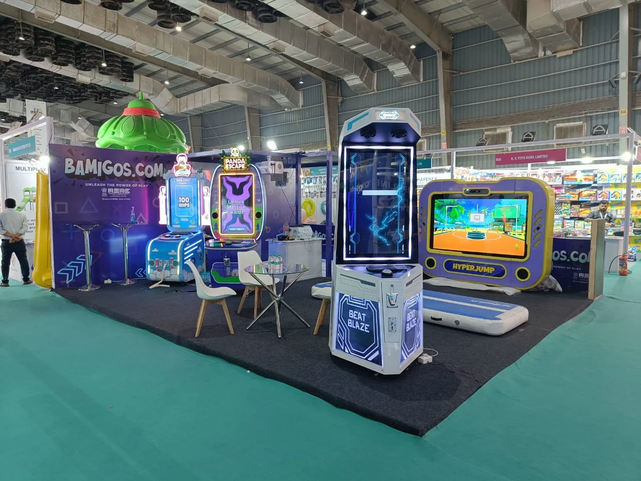Bamigos.com trade show stand with Hyper Jump, Beat Blaze and Panda Escape games running on a teal carpet