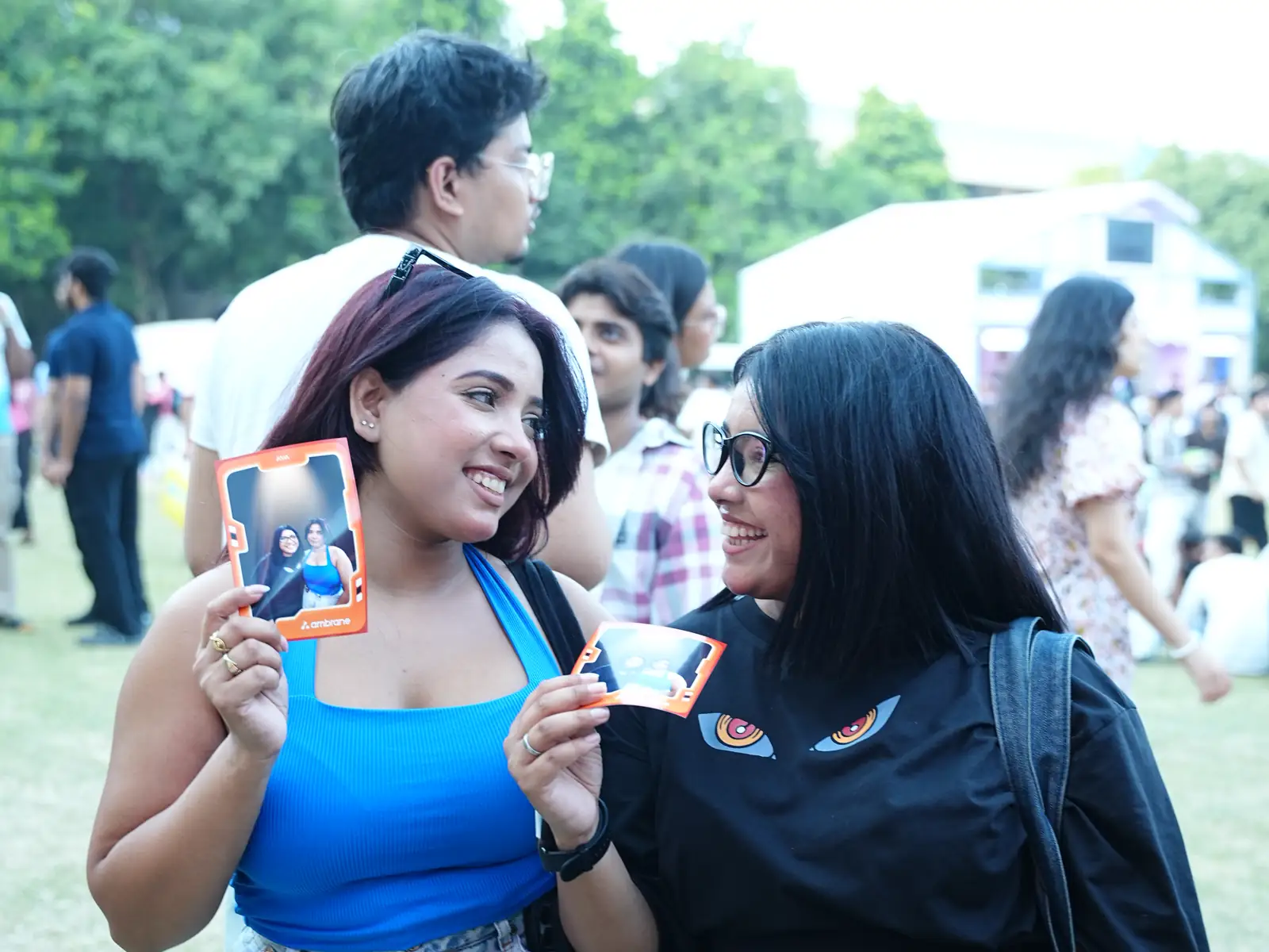 Two students holding instant AI photo prints at a college fest