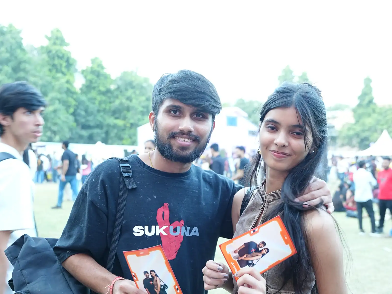 Two guests showing their printed AI photos at a college fest