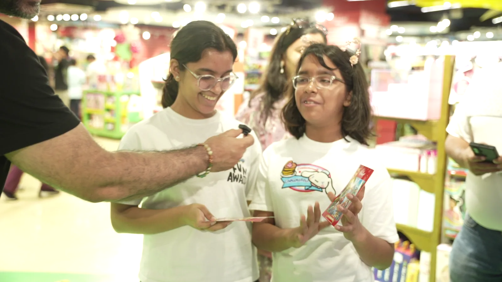 Two girls smiling as a print is handed over at the Pikcha photo booth at Hamleys in Noida