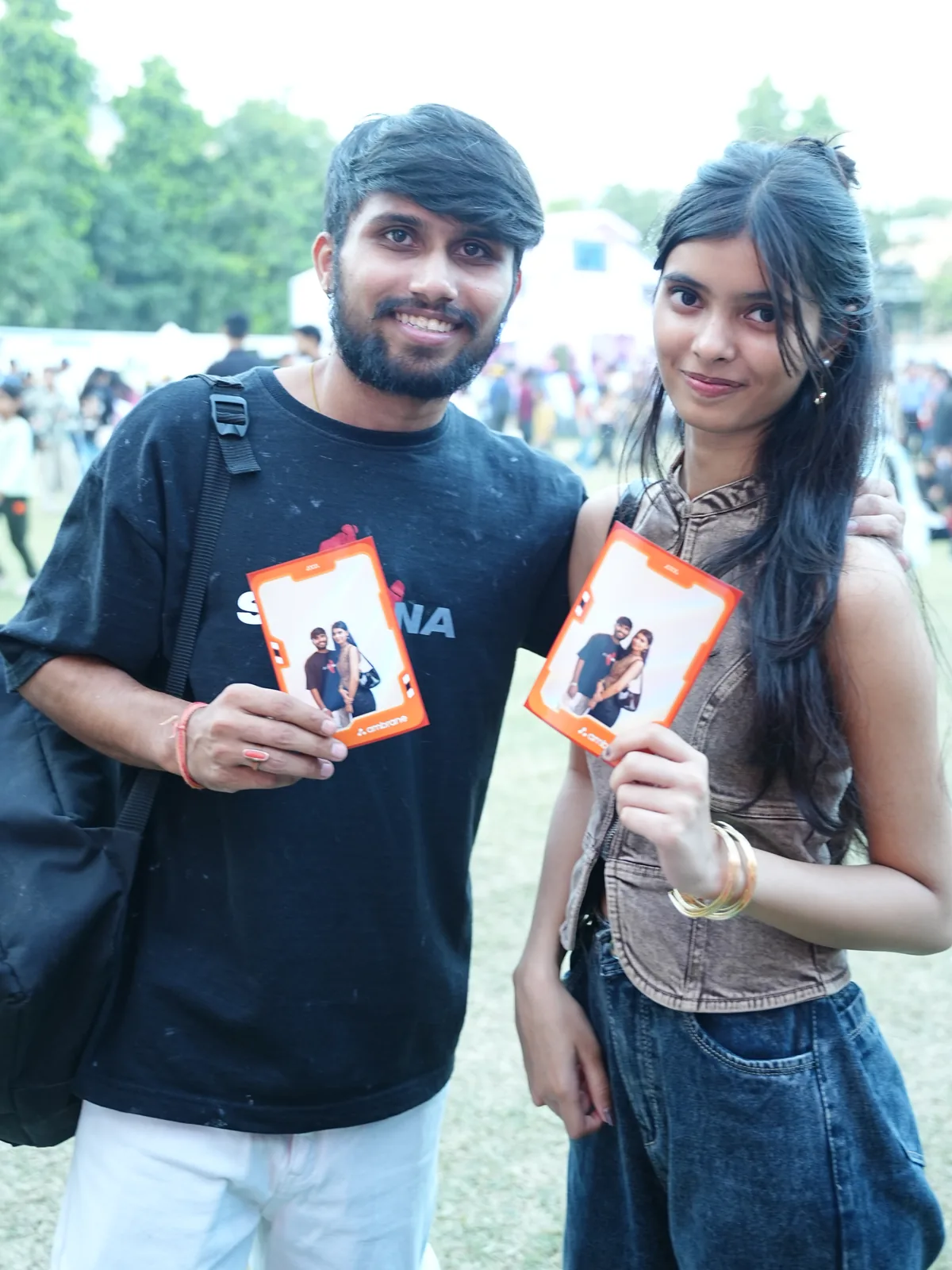 A couple holding their instant prints from the photo booth at a campus event