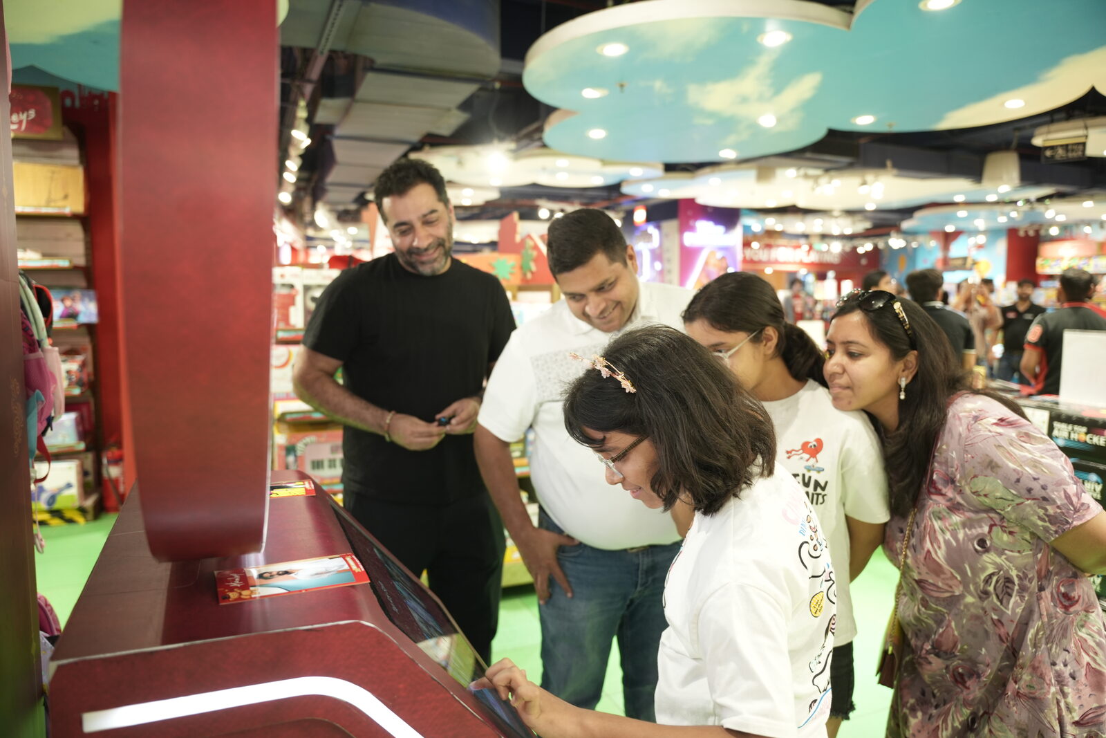 Family using the Pikcha AI photo booth touchscreen at Hamleys in Delhi NCR